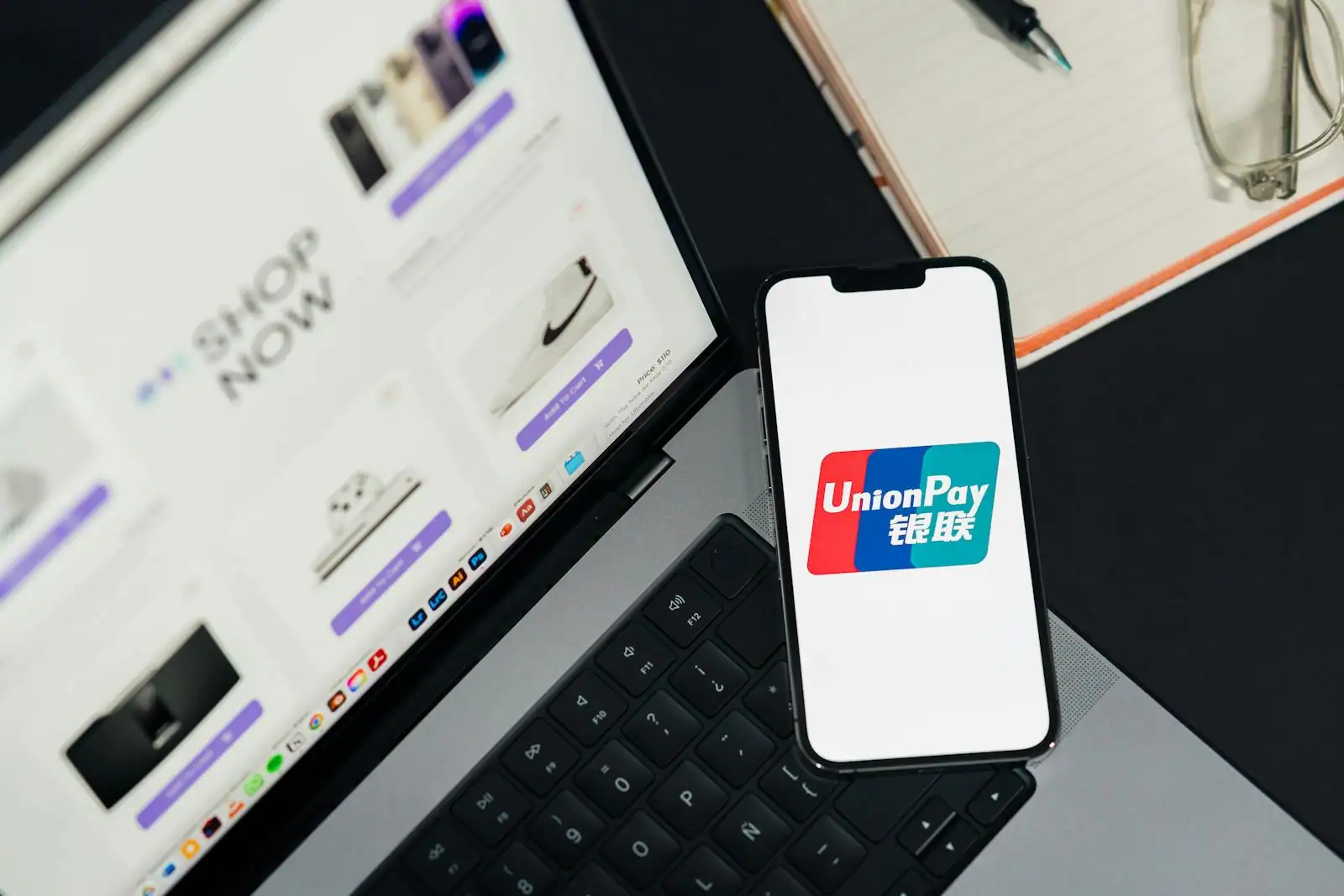 Bureau lumineux avec smartphone affichant une application bancaire et une carte de paiement posée à côté.