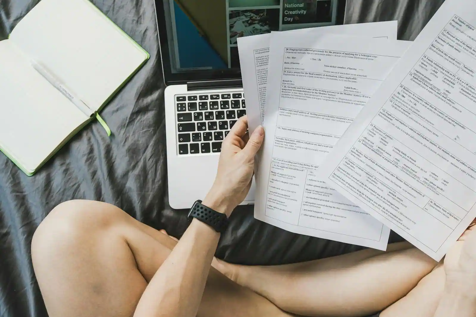 Micro-entrepreneur préparant une facture sur ordinateur portable avec carnet de commandes ouvert à côté