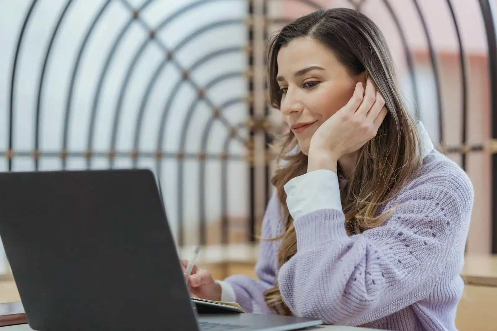 Travailleuse indépendante concentrée devant son ordinateur portable dans un espace de coworking