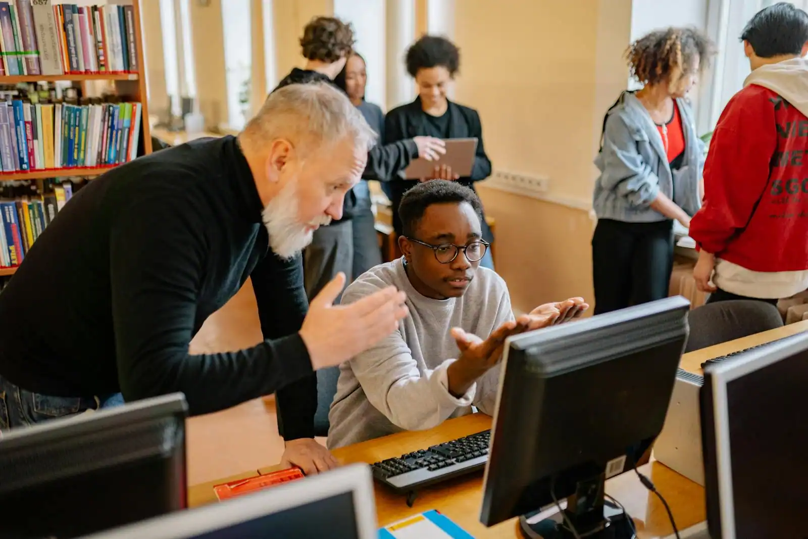 Enseignante accompagnant des lycéens devant un ordinateur lors des démarches d'orientation