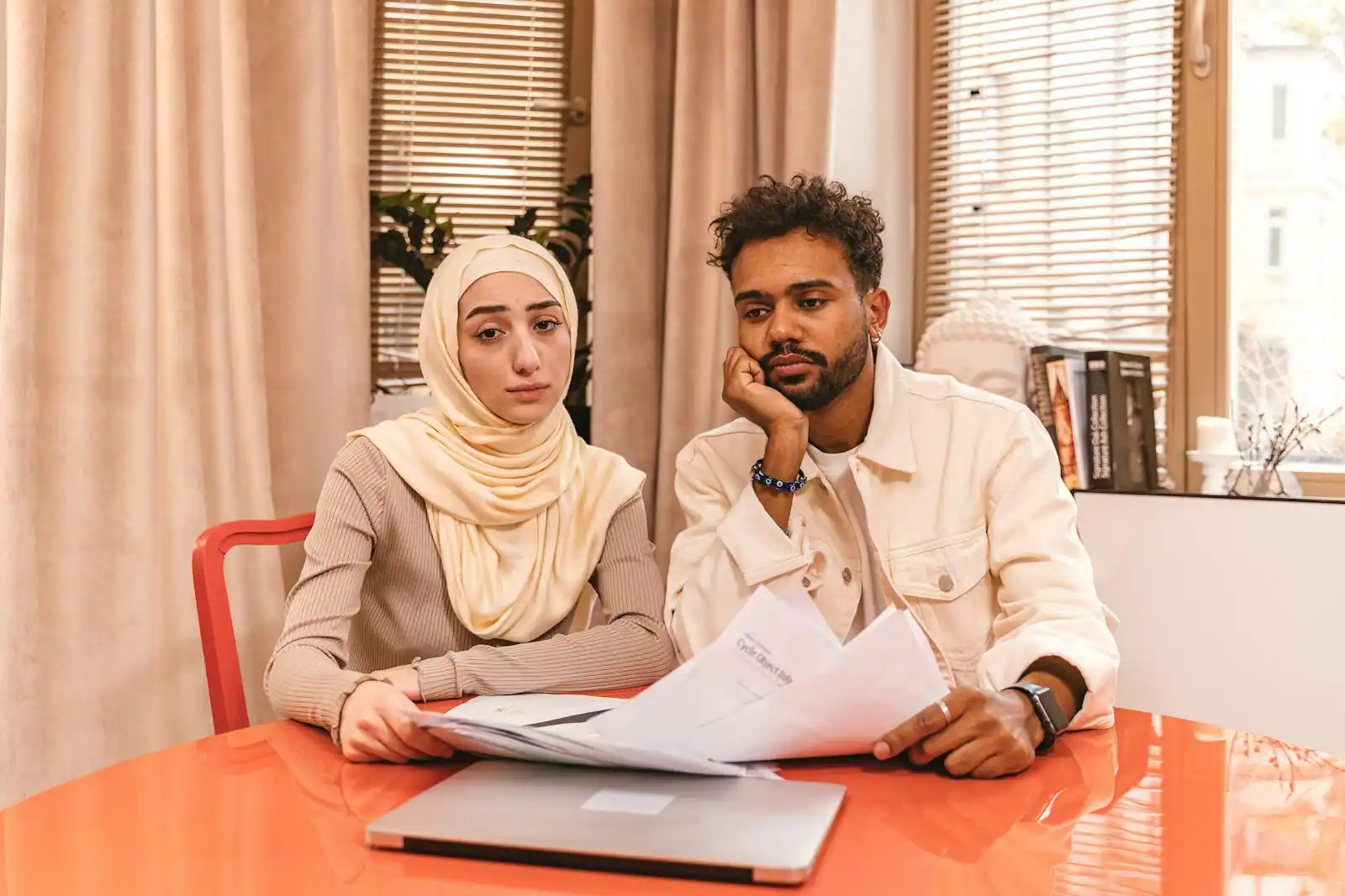 Couple examinant des documents d'épargne et un plan de financement immobilier à la maison