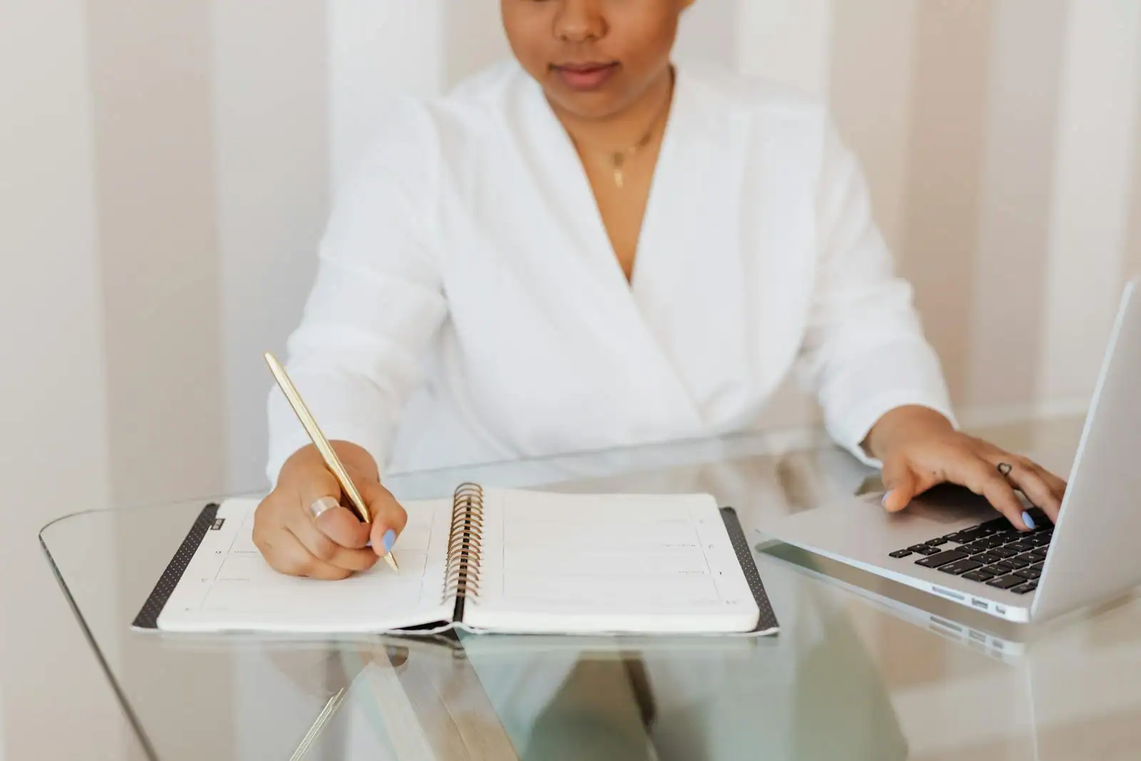 Personne en pleine réflexion devant un ordinateur et des documents, préparant un changement de carrière