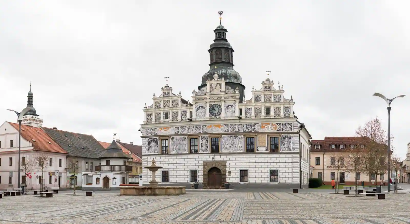 Hôtel de ville historique orné d'une tour, sur une place pavée, bâtiment d'une administration publique