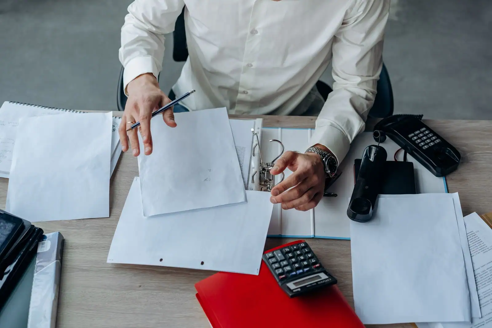 Un responsable organise des documents de gestion dans un espace de travail professionnel et ordonné.