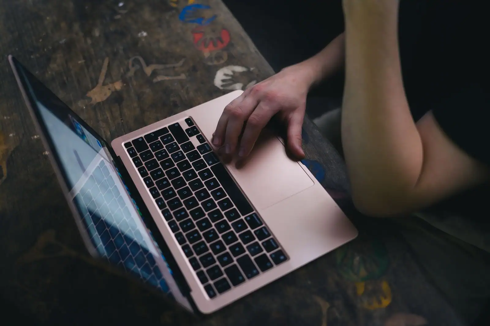 Personne utilisant un ordinateur portable, une main posée sur le clavier.