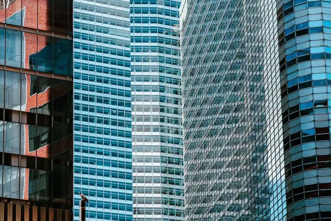 Immeubles de bureaux modernes aux façades vitrées dans un quartier d'affaires en journée.