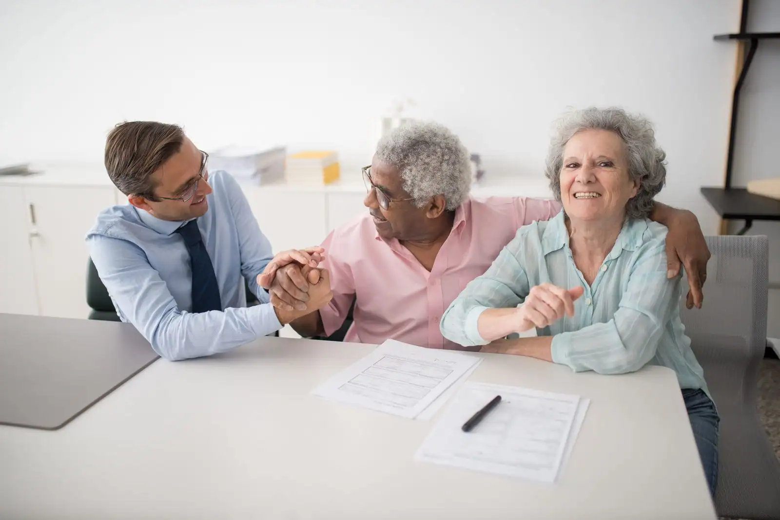 Conseiller financier remettant un contrat à un couple lors d'un rendez-vous