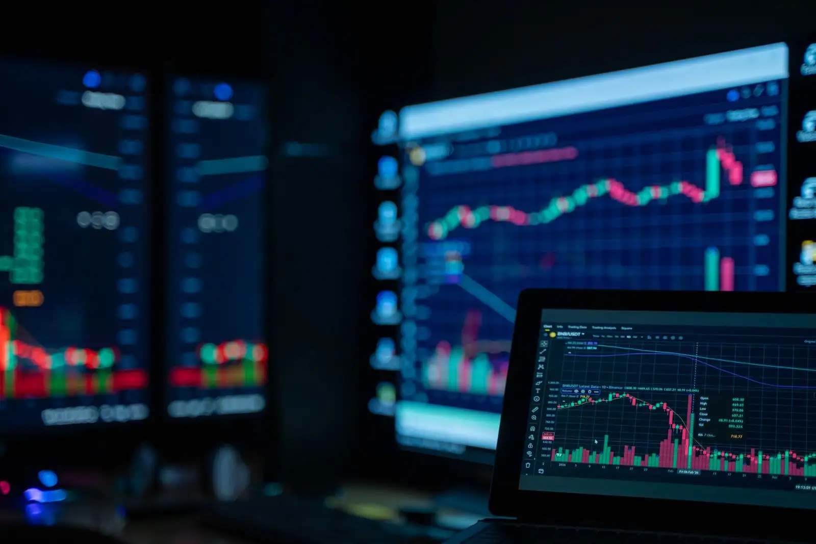Écrans de trading affichant des graphiques de cours en chandeliers sur les marchés financiers
