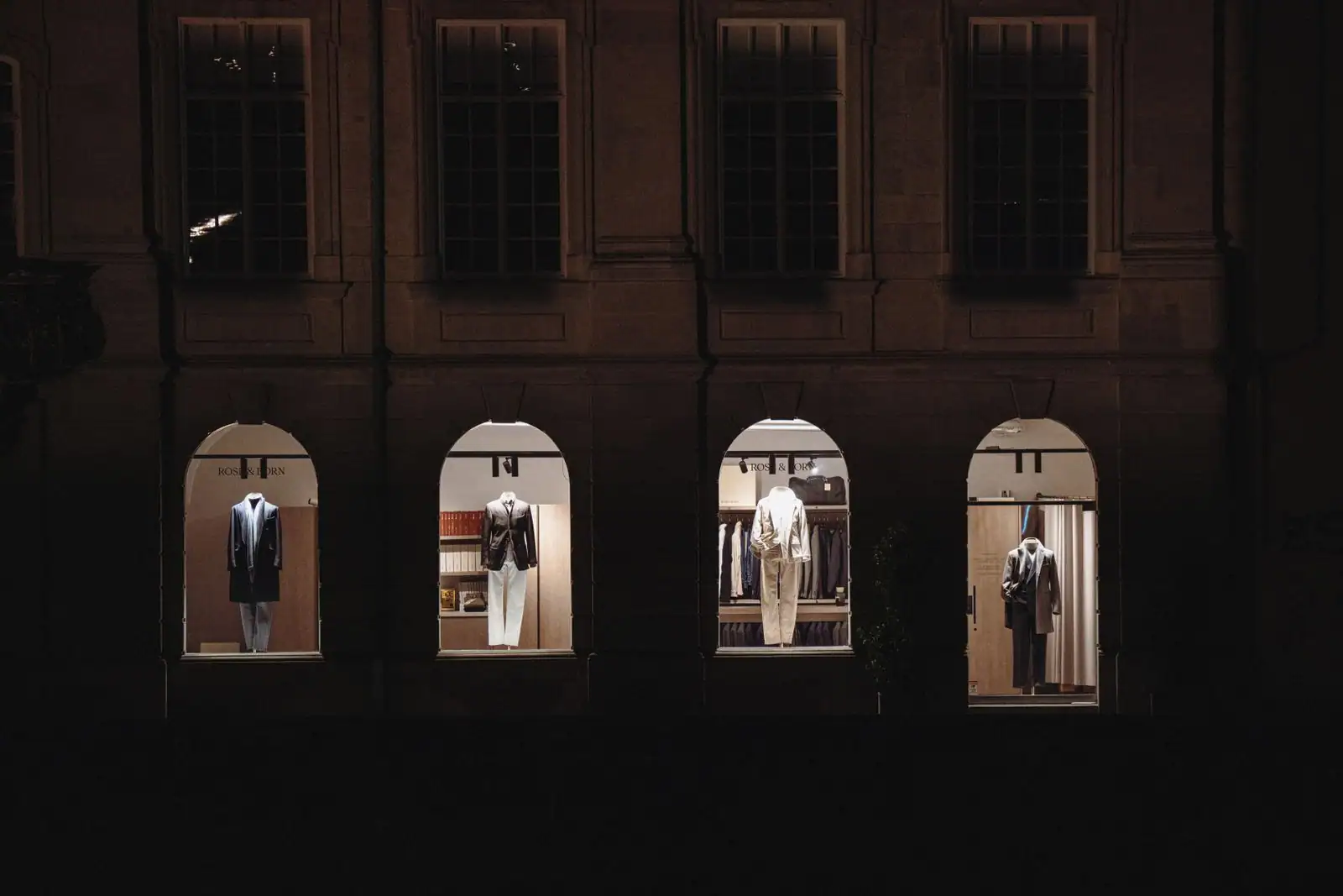 Vitrines éclairées d'une boutique de mode masculine haut de gamme la nuit