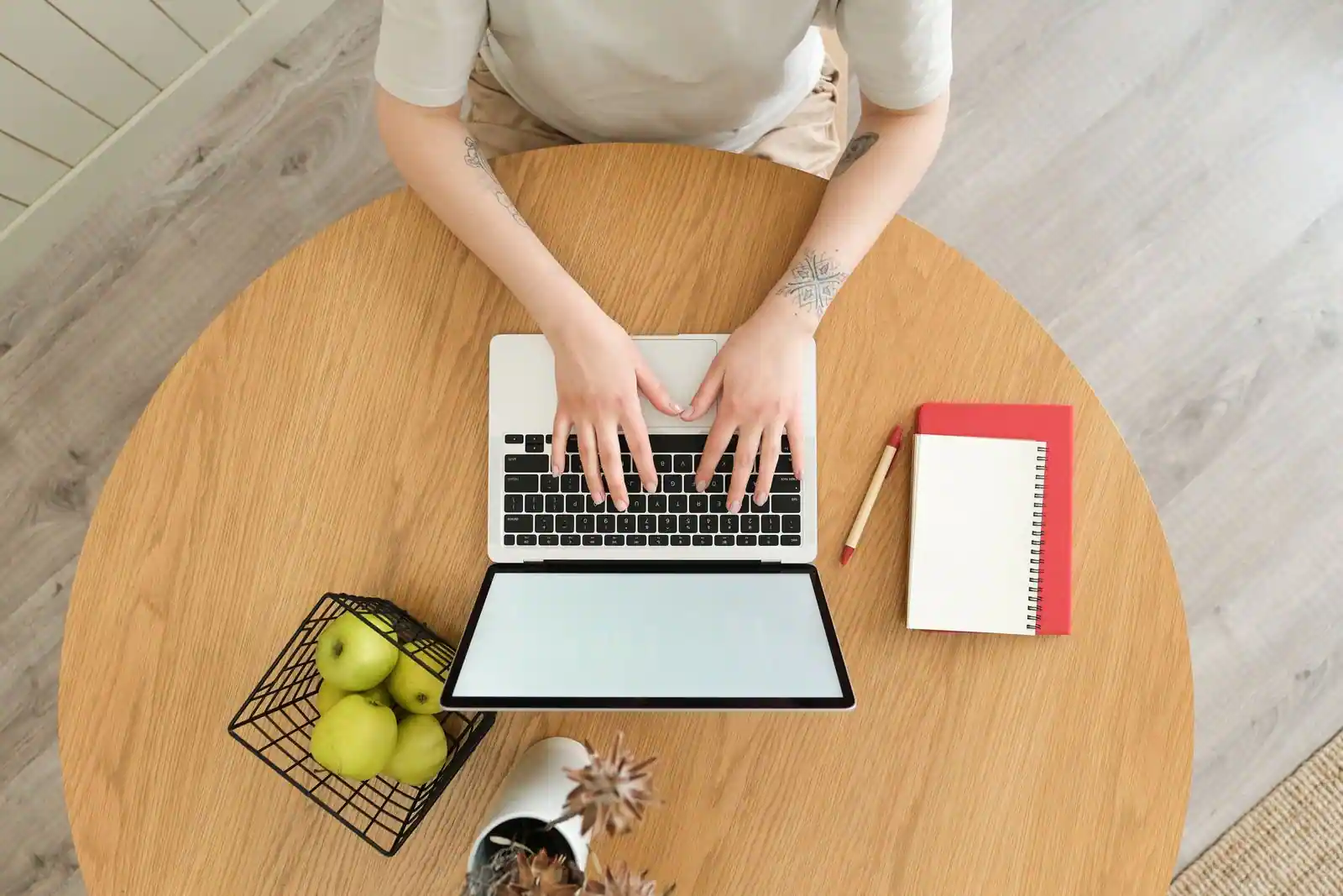 Freelance travaillant sur un ordinateur portable à une table de travail, vue de dessus