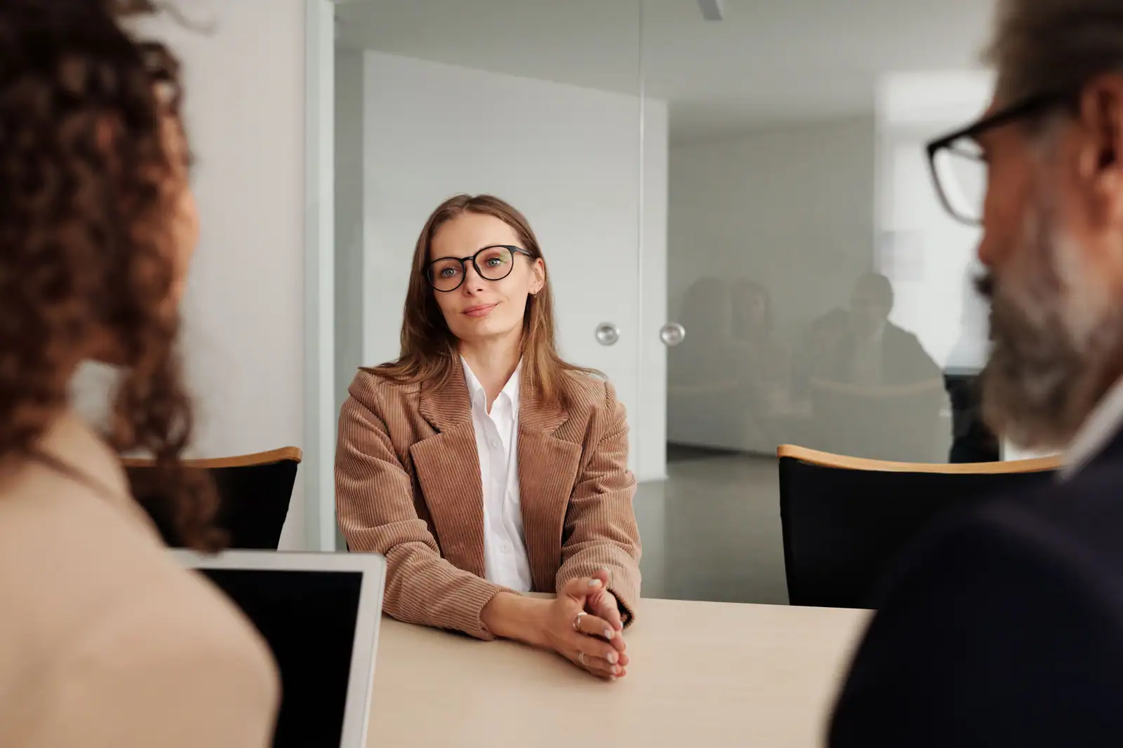 Candidate en entretien d'embauche face à deux recruteurs, autour d'une table dans un bureau